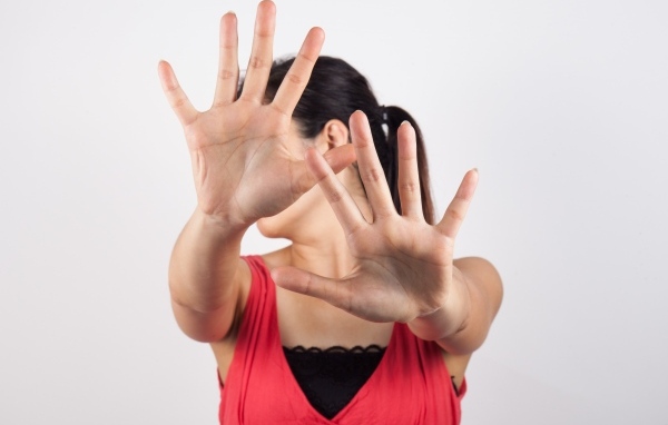 Девушка закрывает лицо руками