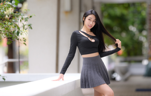 Молодая азиатка в короткой серой юбке