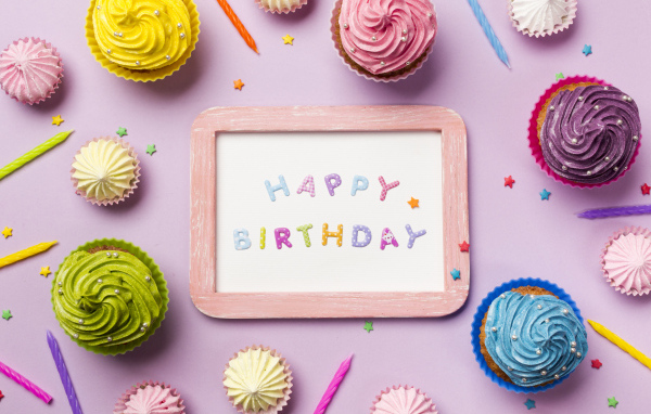 Открытка с днем рождения с кексами и свечами на розовом фоне