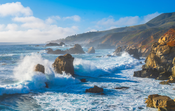 Белые бушующие волны бьются о камни 