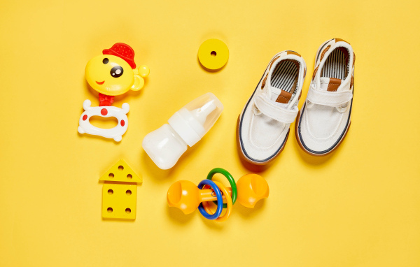 Детские игрушки и обувь на желтом фоне
