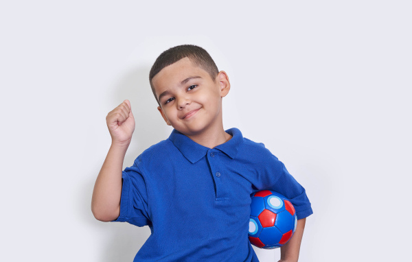 Милый мальчик с мячом на белом фоне