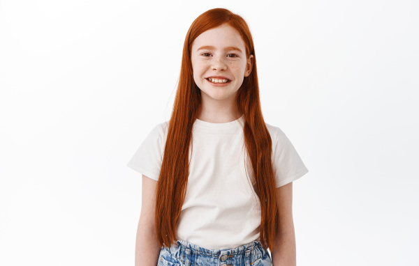 Улыбающаяся рыжеволосая девочка на белом фоне
