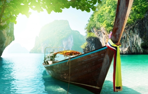 Деревянная рыбацкая лодка в воде на тропическом пляже