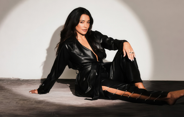 Актриса Натали Мартинес в черном кожаном костюме на фоне серой стены