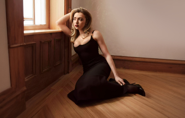 Актриса Пейтон Рой Лист в черном платье сидит на полу у окна