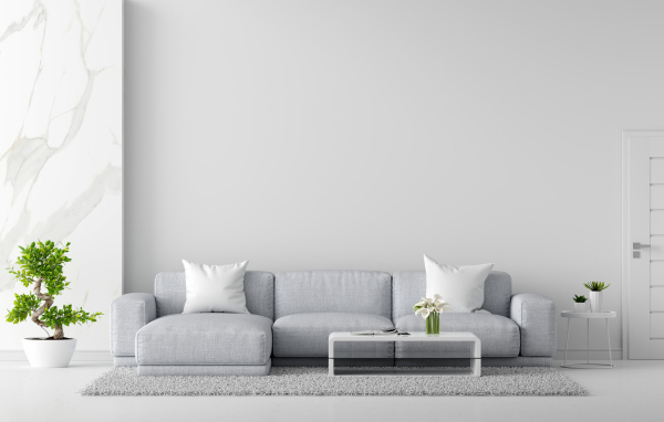 Большой серый диван в комнате с комнатными цветами