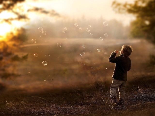 Мальчик запускает мыльные пузыри