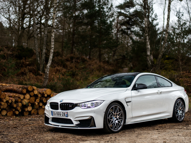 White stylish BMW M4 car on the background of trees