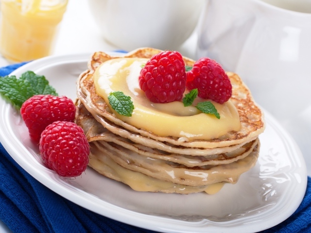 Appetizing pancakes with condensed milk and raspberries