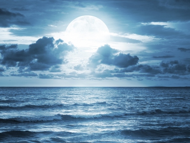 Большая луна в облаках над океаном