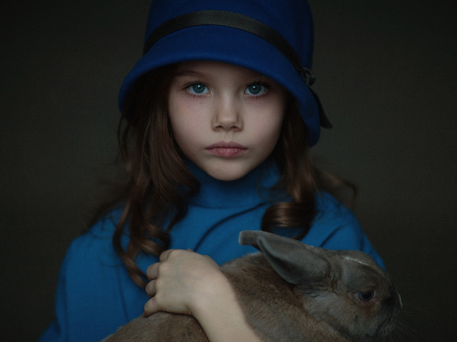 Маленькая девочка в синей шляпе с кроликом