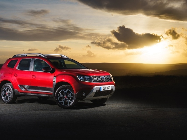 Красный внедорожник Dacia Duster Techroad 2019 года на фоне неба на закате