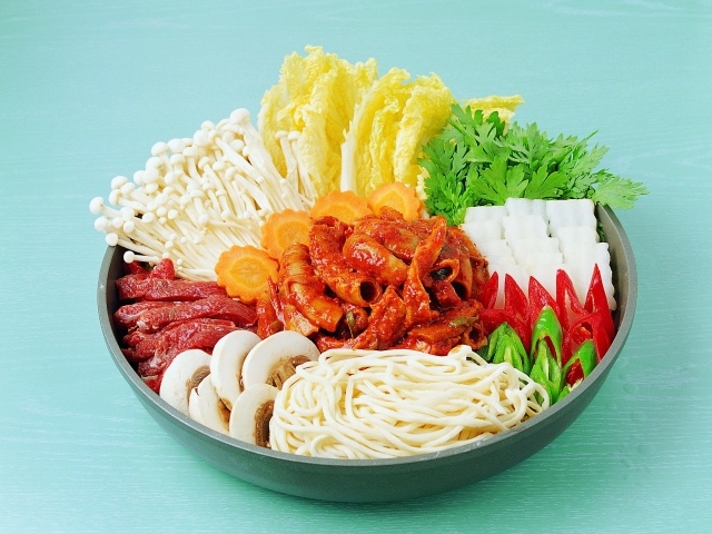 Мясо в тарелке с овощами, грибами и лапшой на голубом фоне