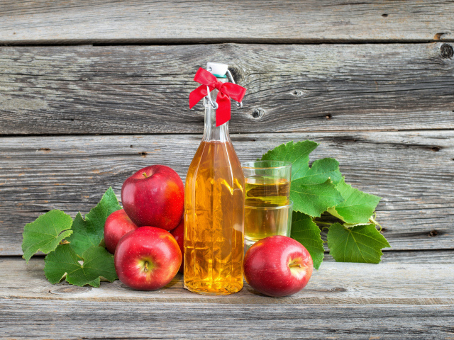 Яблочный сок на столе с красными яблоками
