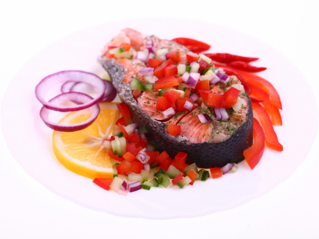 Кусок красной рыбы с овощами на белом фоне