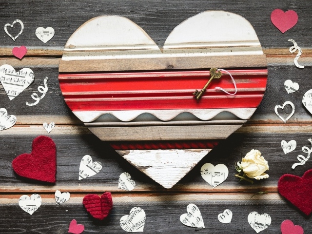 Деревянное сердце с бумажными сердечками на столе