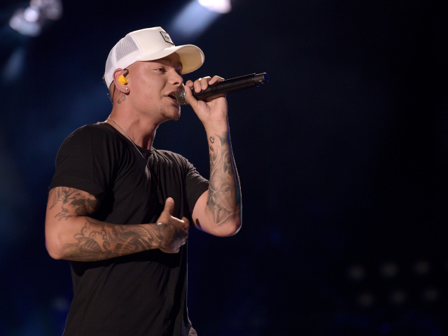 Американский кантри певец Кейн Браун с микрофоном на сцене