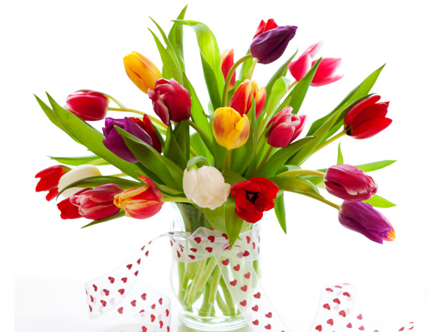 Букет разноцветных тюльпанов в прозрачной вазе с лентой 