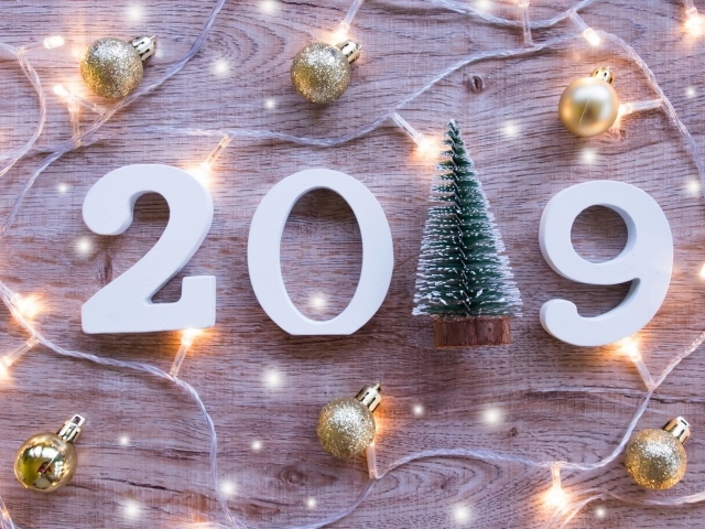 Figures 2019 on a wooden background with Christmas decorations and a garland