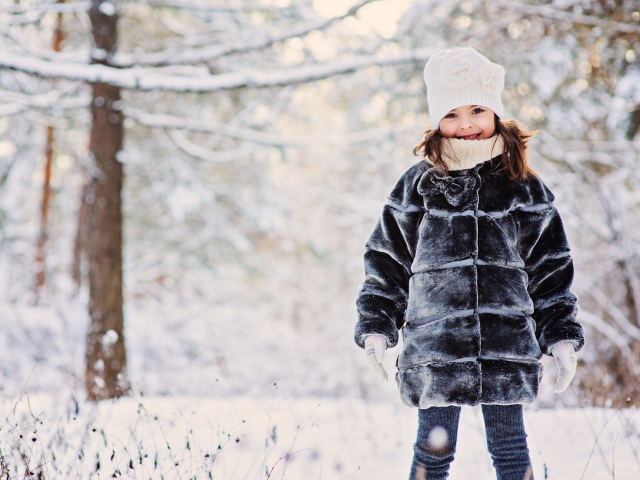 Милая маленькая девочка в шубе зимой