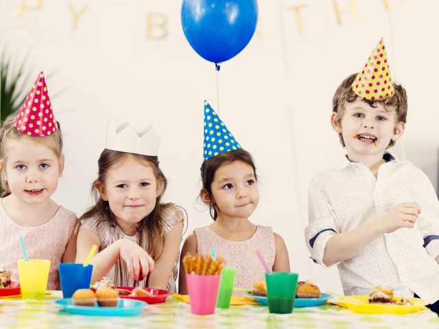 Маленькие дети отмечают детский праздник за столом