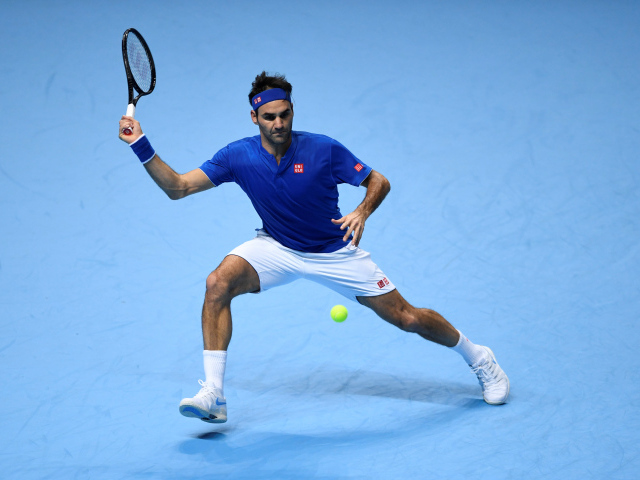 Теннисист Роджер Федерер отбивает мяч ракеткой на корте 
