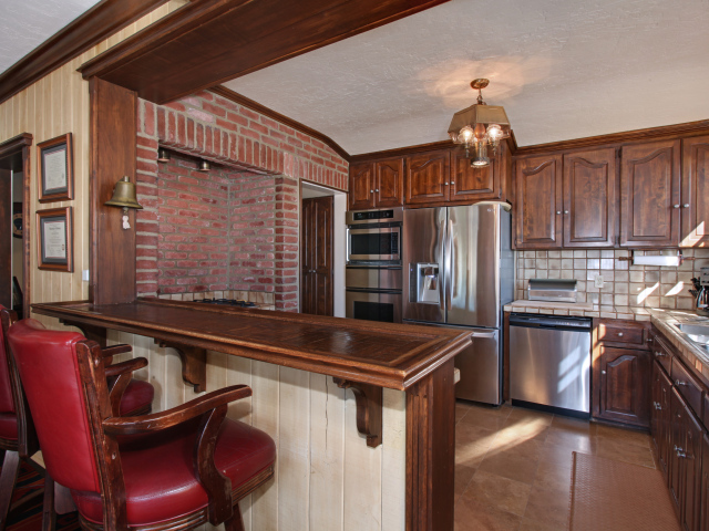 Spacious kitchen with wooden furniture and leather chairs