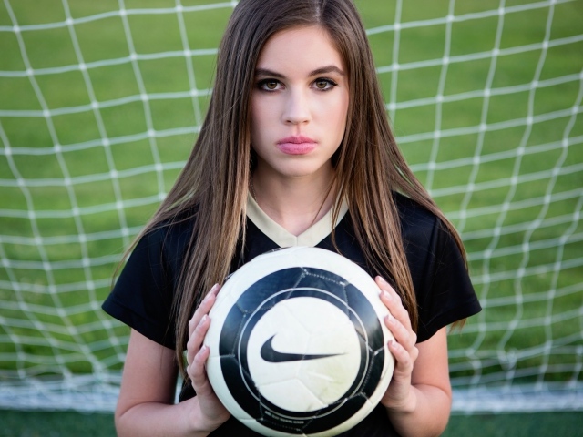 Спортивная девушка вратарь с мячом в воротах 