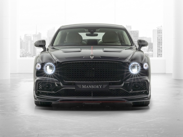 Черный автомобиль Mansory Bentley Flying Spur 2020 года с включенными фарами 