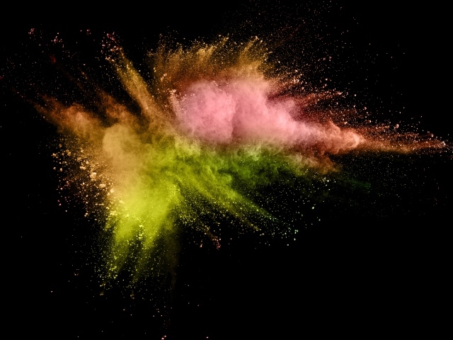 Взрыв разноцветной краски на черном фоне