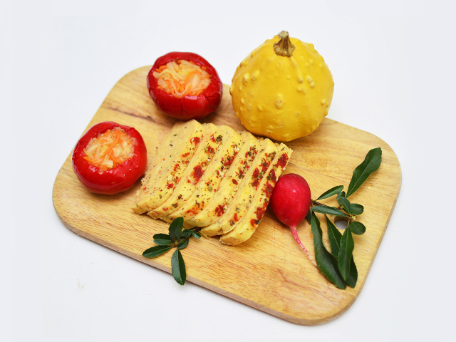Cheese with vegetables on a cutting board on a white background