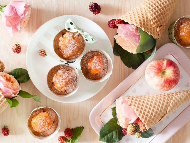 Вкусные кексы с абрикосом на столе с вафельными рожками с розой и ежевикой