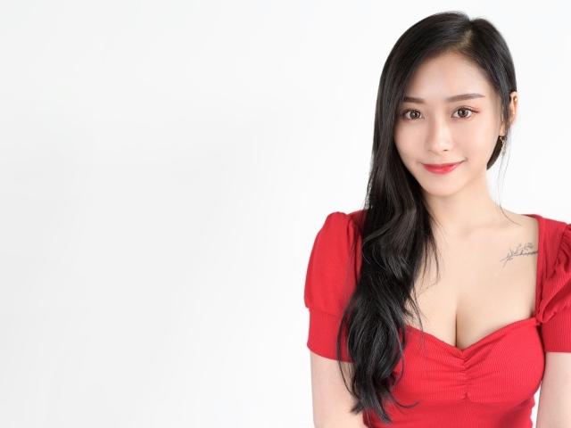 Beautiful Asian girl in a red dress on a white background