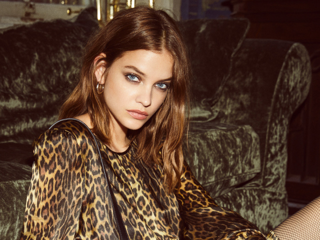Model Barbara Palvin in a leopard dress by the sofa