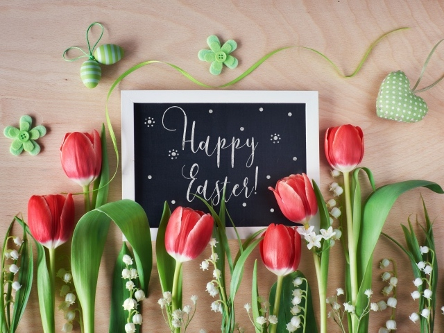 Надпись Счастливой Пасхи на столе с букетом тюльпанов
