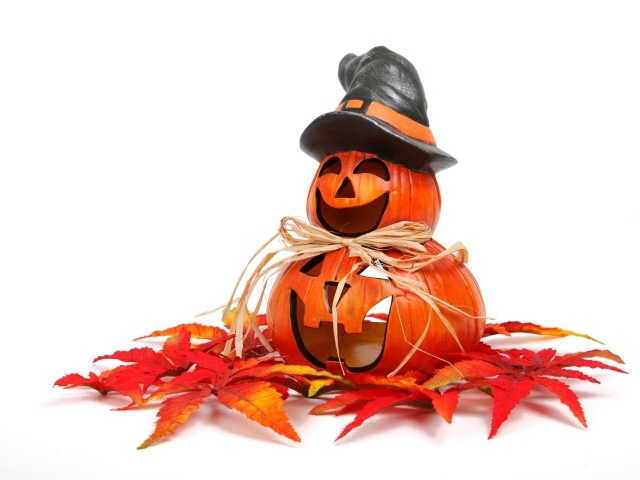 Статуэтка тыквы на белом фоне с листьями на праздник Хэллоуин
