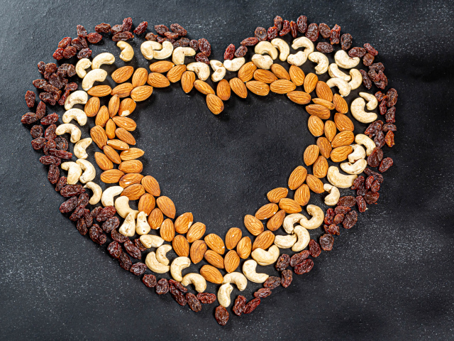 Heart made of nuts and raisins on a gray background