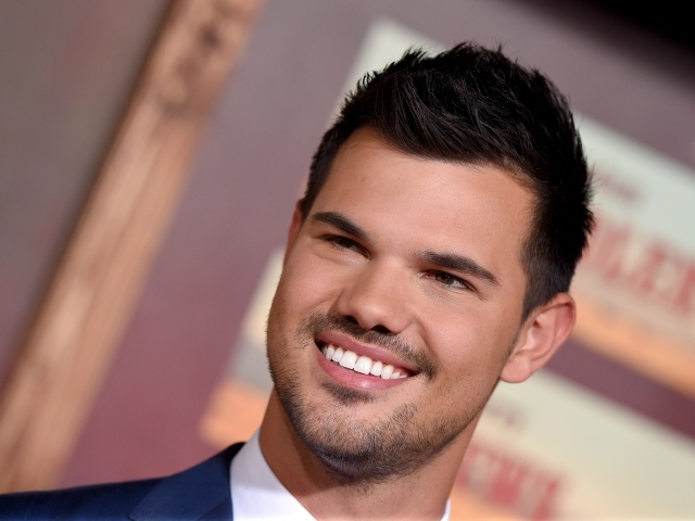 Улыбающийся молодой мужчина, актер Тэйлор Лотнер