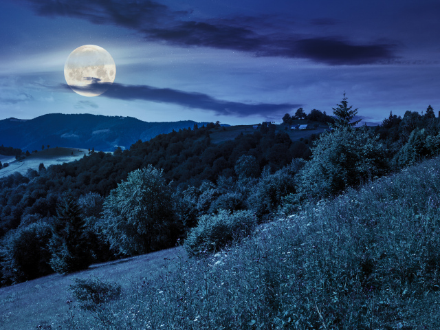 Big moon in the night sky over the hills