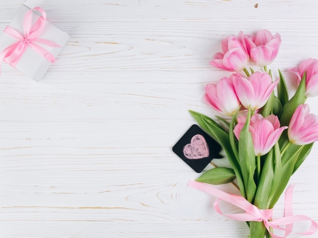 Красивый букет розовых тюльпанов с подарком на сером фоне