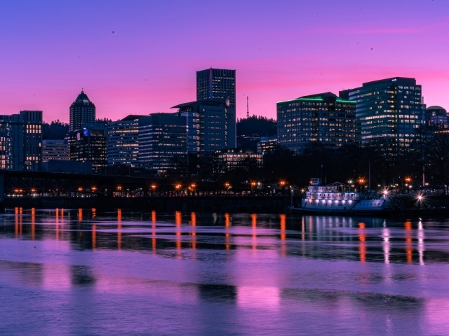 Lilac sunset over the night city by the river