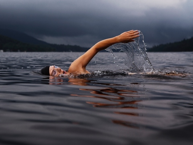 Male swimmer in the lake water