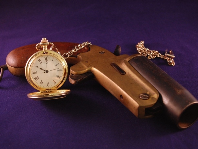 Старый пистолет с песочными часами на фиолетовом фоне