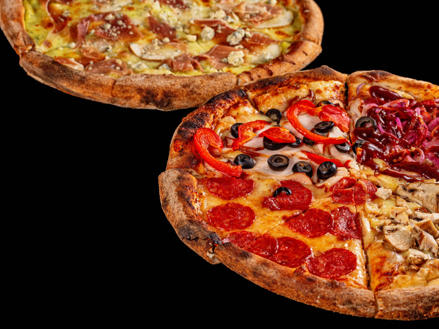 Two delicious pizzas on a black table