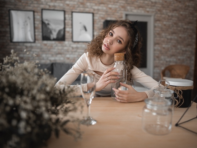 Молодая девушка модель сидит в кафе за столом