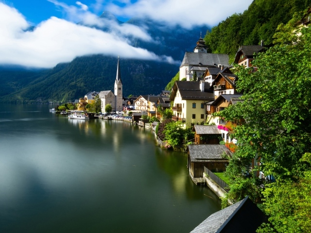 Beautiful houses on the shore of a calm lake at the foot of the mountains