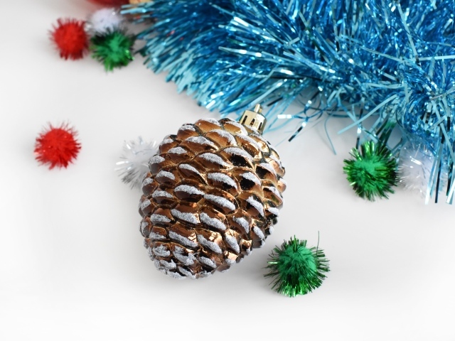 Christmas toy pine cone with tinsel on a white background