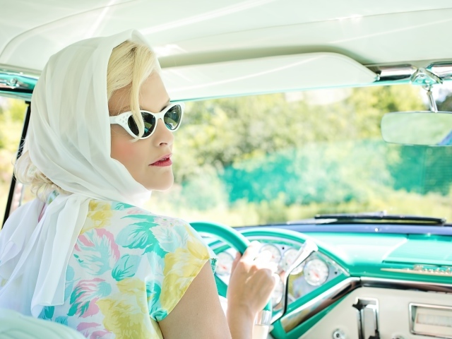 Retro girl with glasses in an old car
