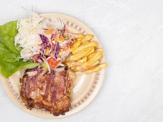 Meat on a plate with french fries and salad